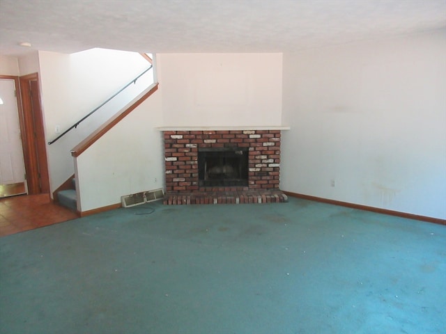 unfurnished living room featuring carpet flooring and a brick fireplace