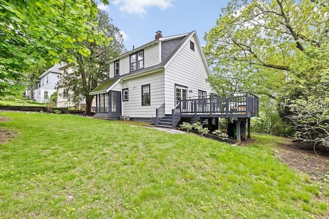 rear view of property with a wooden deck, a yard, and a chimney