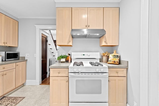 kitchen featuring white gas stove, under cabinet range hood, stainless steel microwave, light brown cabinets, and crown molding
