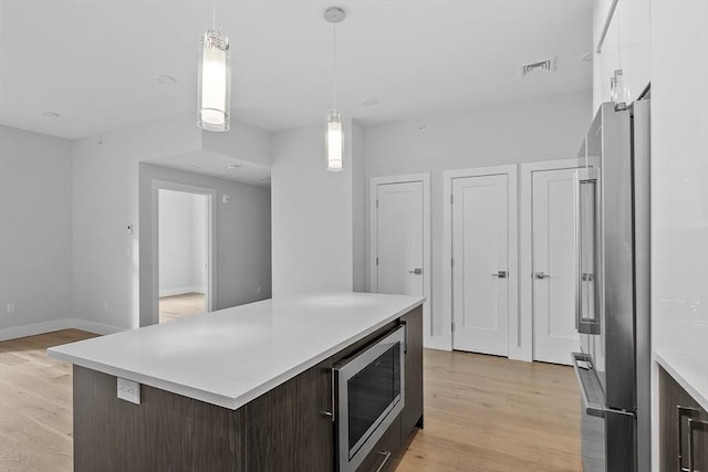kitchen featuring visible vents, light countertops, light wood-type flooring, and appliances with stainless steel finishes