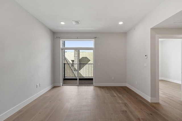 spare room featuring baseboards, visible vents, wood finished floors, and recessed lighting