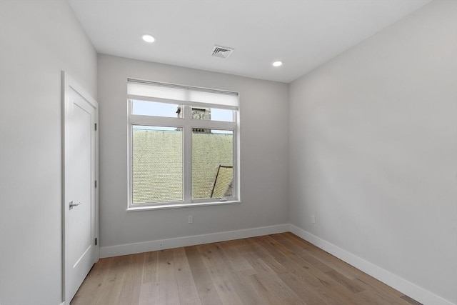 empty room with baseboards, visible vents, light wood-style floors, and plenty of natural light