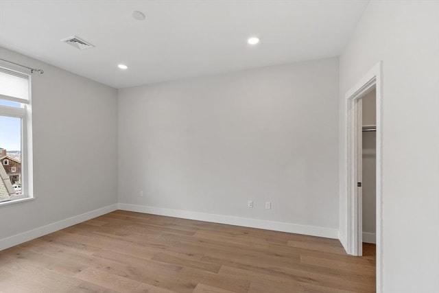 empty room with light wood-style flooring, recessed lighting, baseboards, and visible vents