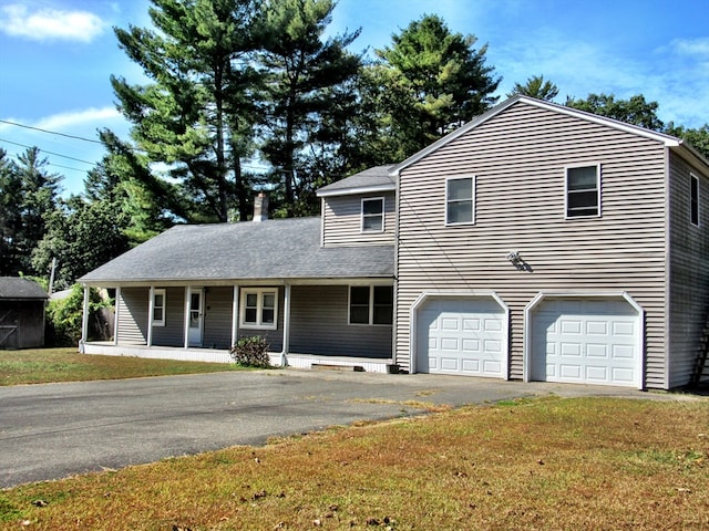 view of front of house featuring a garage, a front lawn, and a porch