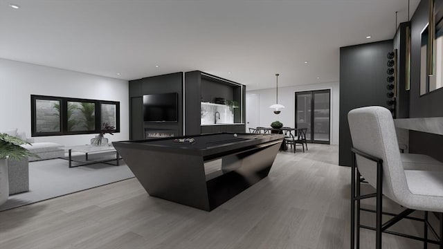 kitchen featuring hanging light fixtures, a kitchen bar, and light hardwood / wood-style flooring