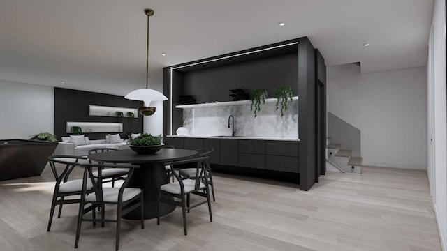 dining room featuring sink and light hardwood / wood-style floors