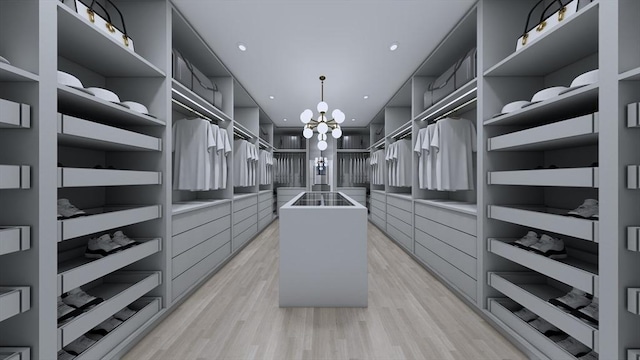 spacious closet featuring a notable chandelier and light hardwood / wood-style flooring