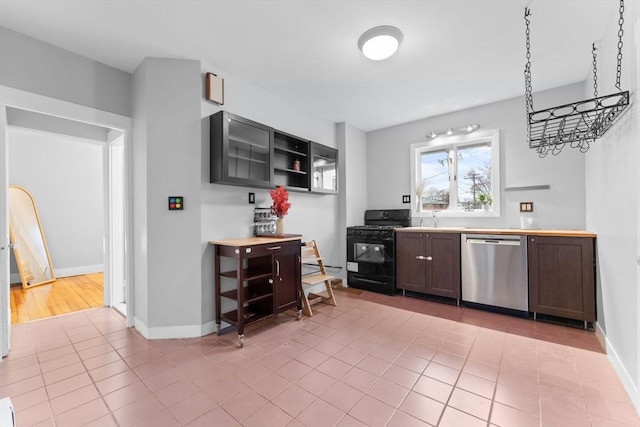 253 Sycamore St Unit 1, Watertown, MA 02472 - kitchen featuring black range with gas cooktop, dishwasher, baseboards, a sink, and light tile patterned floors
