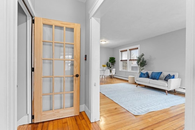 253 Sycamore St Unit 1, Watertown, MA 02472 - foyer with baseboard heating, hardwood / wood-style floors, and baseboards