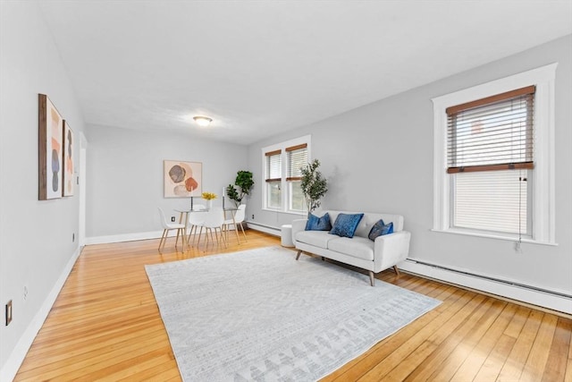 253 Sycamore St Unit 1, Watertown, MA 02472 - living area featuring light wood finished floors, a baseboard radiator, a baseboard heating unit, and baseboards