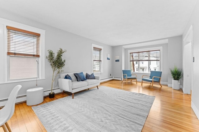 253 Sycamore St Unit 1, Watertown, MA 02472 - living area featuring light wood-type flooring, a baseboard heating unit, baseboards, and baseboard heating