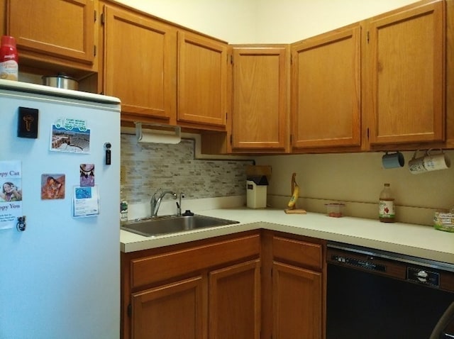 kitchen with white refrigerator, dishwasher, tasteful backsplash, and sink