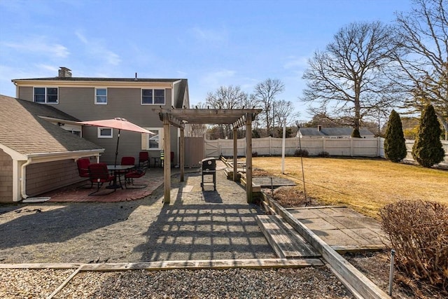 exterior space featuring a chimney, a patio area, a lawn, a pergola, and fence
