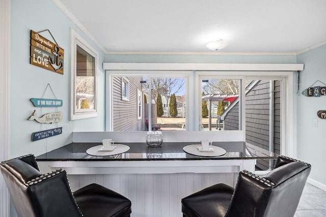 dining area with ornamental molding and baseboards
