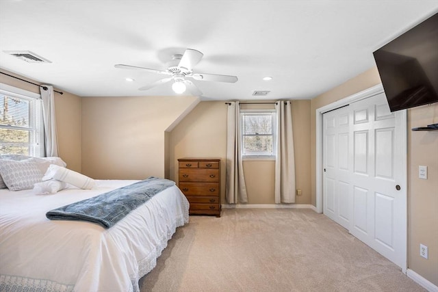 bedroom with baseboards, visible vents, multiple windows, and light colored carpet