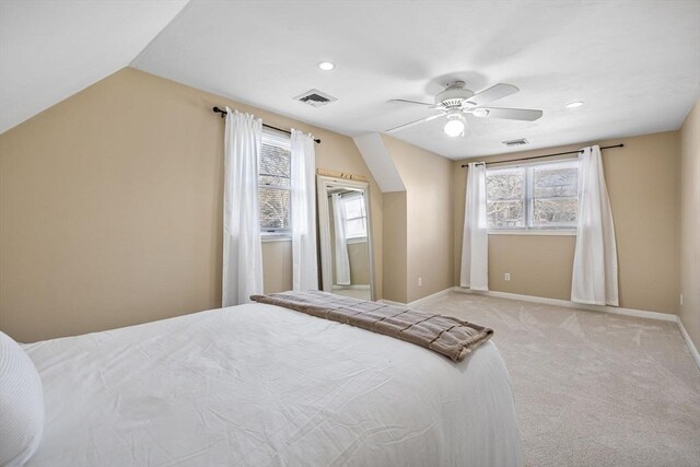 bedroom featuring visible vents, ceiling fan, baseboards, vaulted ceiling, and light carpet