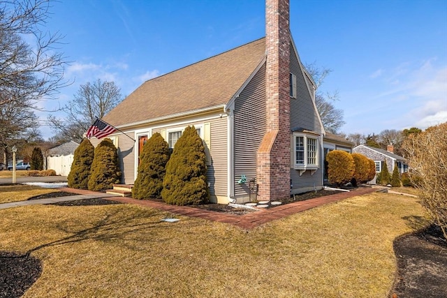 view of property exterior featuring a lawn, a chimney, and a shingled roof