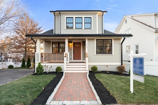 view of front facade with covered porch and a front yard