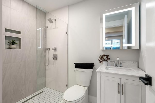 bathroom featuring vanity, toilet, and a shower with door