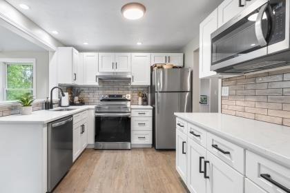 537 S River St, Marshfield, MA 02050 - kitchen with appliances with stainless steel finishes, a sink, decorative backsplash, and white cabinets