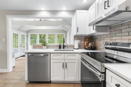 537 S River St, Marshfield, MA 02050 - kitchen with appliances with stainless steel finishes, a sink, under cabinet range hood, white cabinetry, and recessed lighting