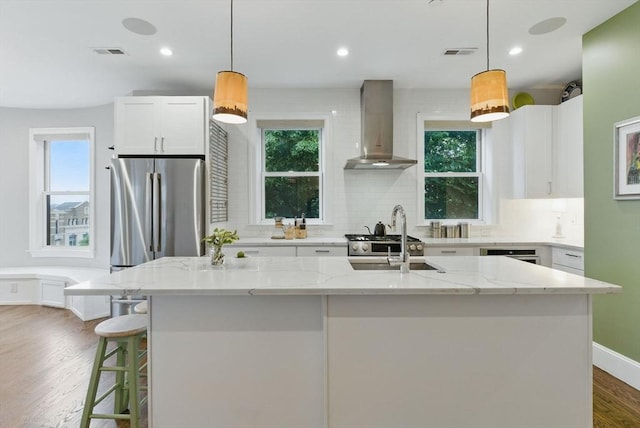 1650 Columbia Rd Unit 3, Boston, MA 02127 - kitchen with wall chimney exhaust hood, freestanding refrigerator, decorative backsplash, white cabinetry, and light stone counters