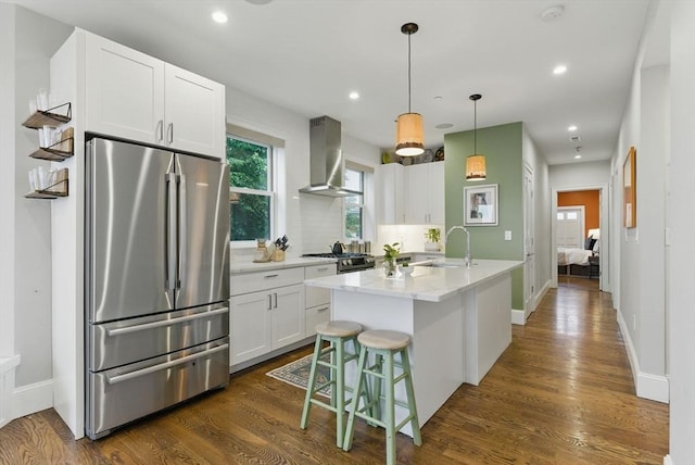 1650 Columbia Rd Unit 3, Boston, MA 02127 - kitchen with stainless steel appliances, wall chimney range hood, white cabinets, dark wood-style flooring, and a center island with sink