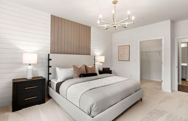 bedroom with light carpet, a chandelier, a walk in closet, a closet, and wood walls