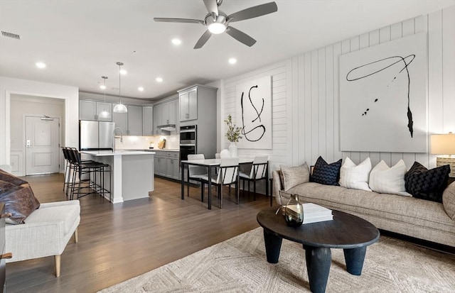 living area featuring ceiling fan, wood finished floors, and recessed lighting