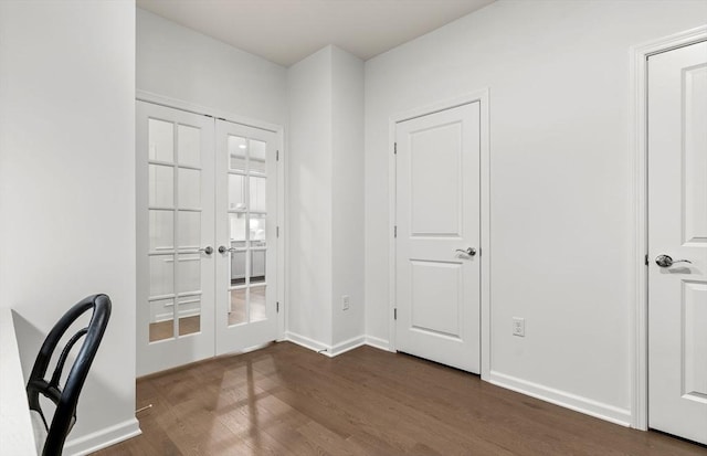 unfurnished office with french doors, dark wood-style flooring, and baseboards