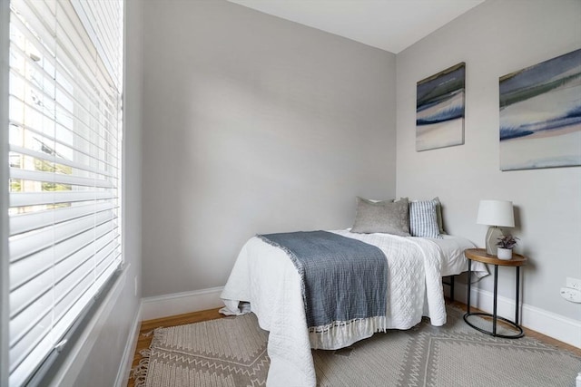 bedroom featuring baseboards and wood finished floors
