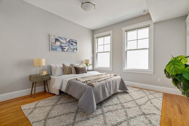 bedroom with baseboards and wood finished floors