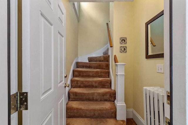 staircase with radiator and baseboards