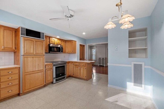 kitchen featuring a peninsula, visible vents, baseboards, light countertops, and appliances with stainless steel finishes