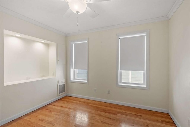 empty room featuring light wood-style floors, ornamental molding, and baseboards