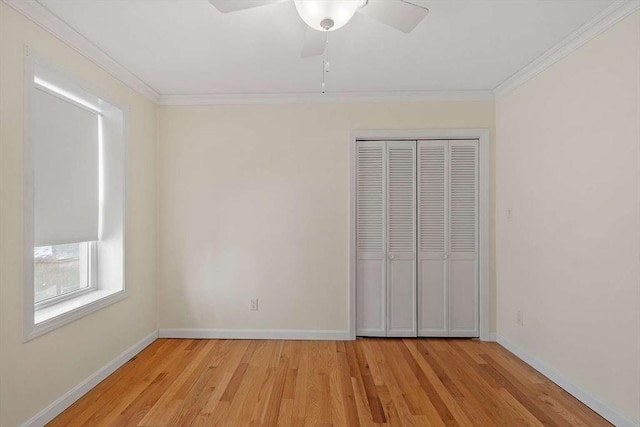 unfurnished bedroom with baseboards, a closet, light wood-style flooring, and crown molding