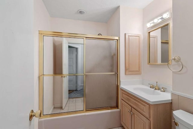 full bathroom with bath / shower combo with glass door, vanity, and toilet