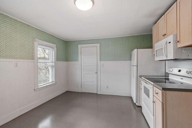 kitchen featuring a wainscoted wall, dark countertops, light brown cabinets, white appliances, and wallpapered walls