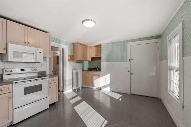 kitchen featuring white appliances, radiator heating unit, and wallpapered walls