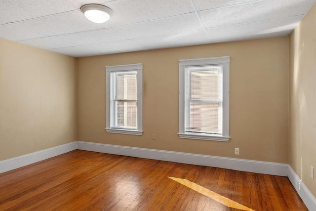 unfurnished room featuring baseboards and wood finished floors