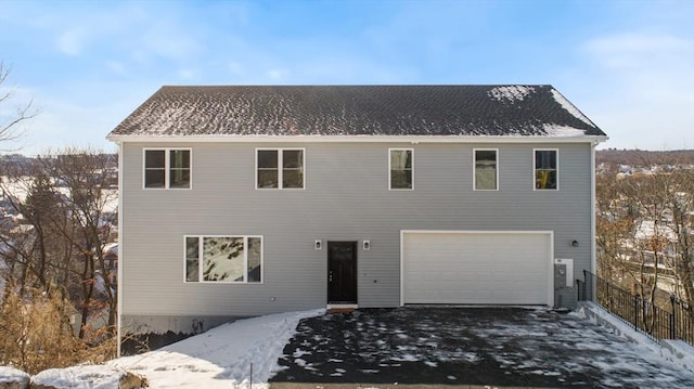 snow covered property with a garage