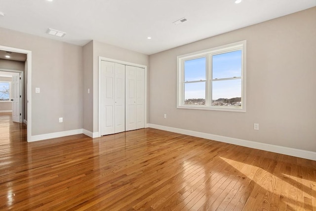 unfurnished bedroom with wood-type flooring and a closet