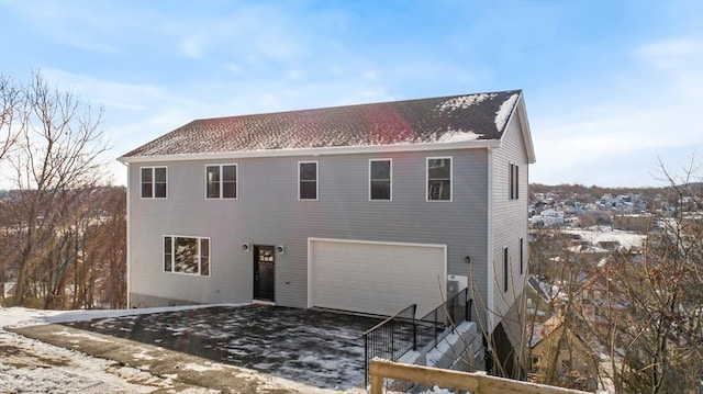 snow covered property with a garage