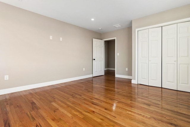 unfurnished bedroom with hardwood / wood-style floors and a closet