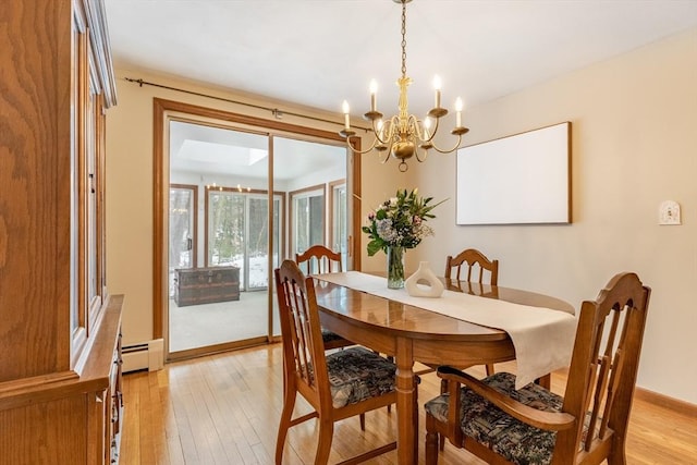 dining area featuring a baseboard heating unit, a chandelier, light wood-style flooring, and baseboards