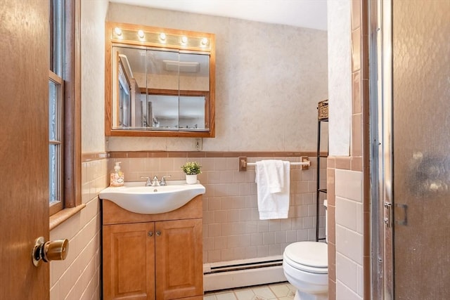 full bathroom featuring toilet, a baseboard radiator, vanity, and tile walls