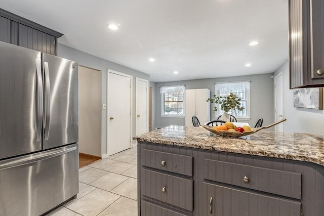 kitchen featuring light tile patterned floors, recessed lighting, gray cabinets, freestanding refrigerator, and light stone countertops