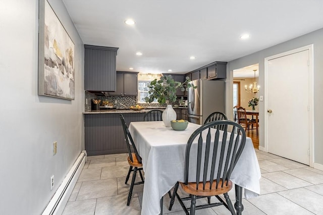 dining space featuring a notable chandelier, baseboard heating, light tile patterned flooring, and recessed lighting