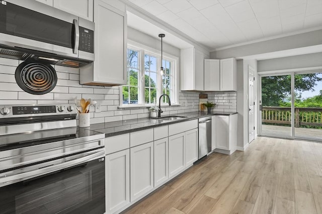 112 Brookline St, Worcester, MA 01603 - kitchen featuring appliances with stainless steel finishes, healthy amount of natural light, tasteful backsplash, white cabinetry, and ornamental molding