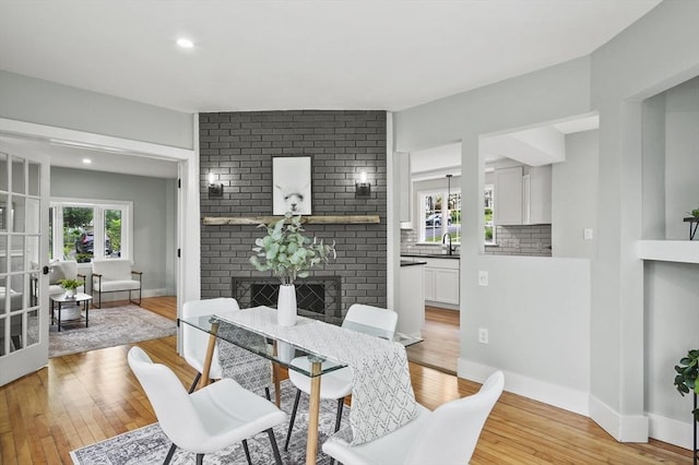 112 Brookline St, Worcester, MA 01603 - dining room with light wood-type flooring, a brick fireplace, and recessed lighting